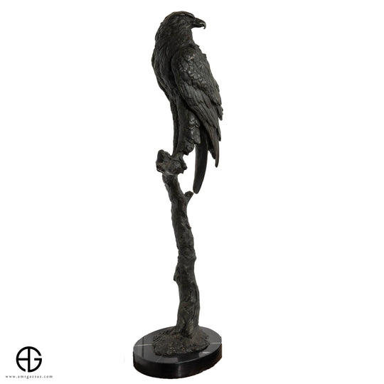 تمثال صقر برونزي على جذع شجرة