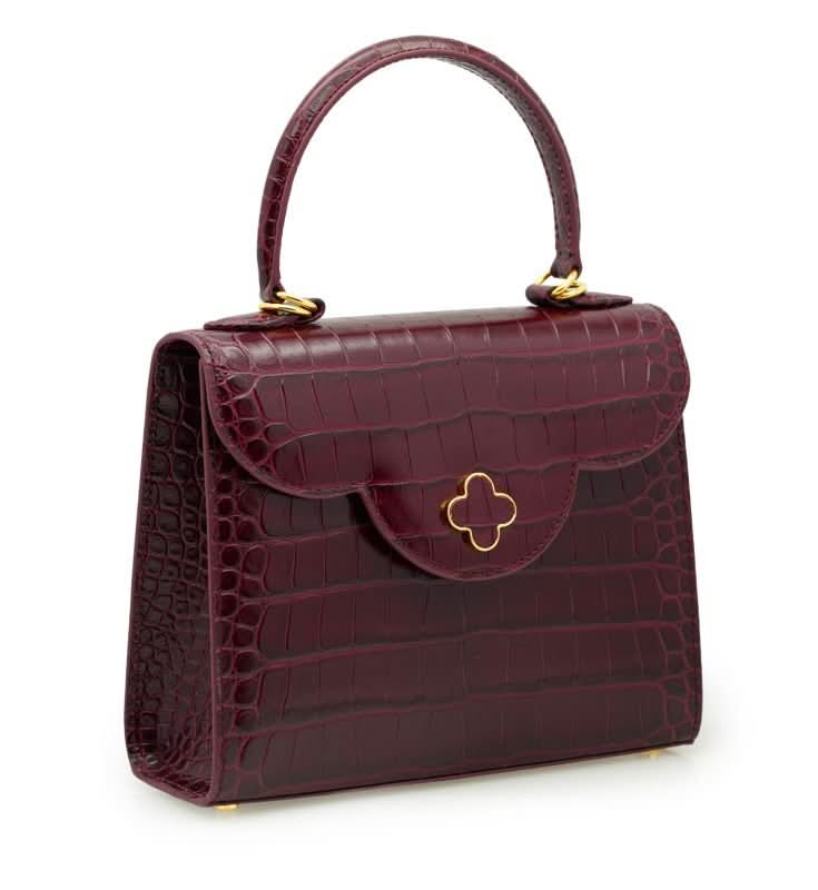 حقيبة يد جلدية منقوش عليها جلد التمساح باللون العنابي للسيدة الأولى